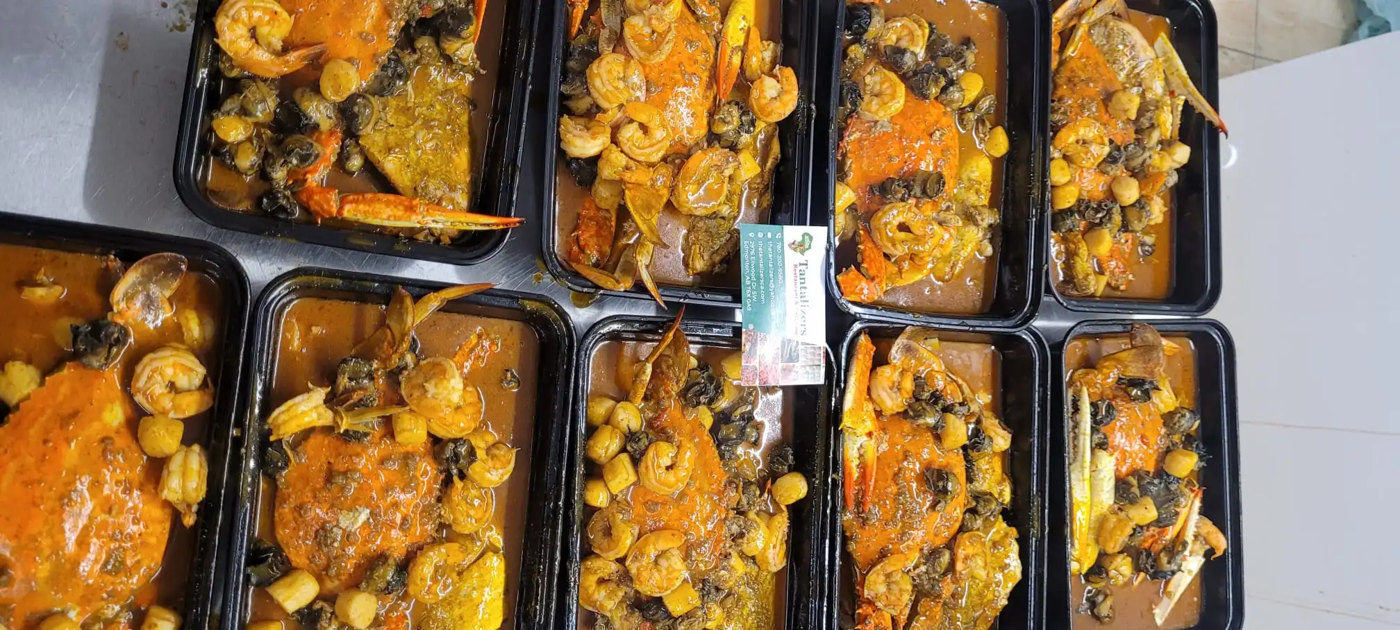 Assorted catering dishes including plantain and sides - The Tantalizers African House